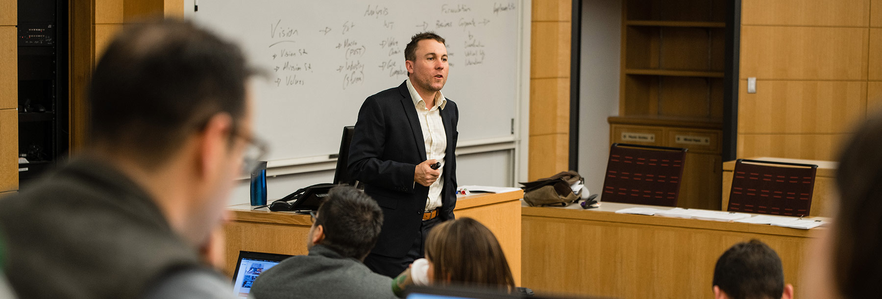 A professor speaks in front of a classroom.